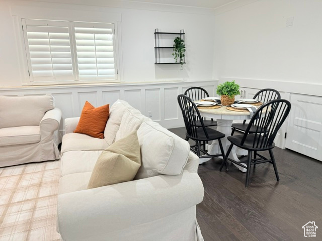 Interior space featuring wainscoting, ornamental molding, a decorative wall, and wood finished floors