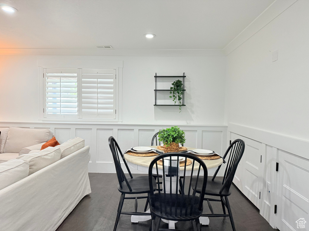 Dining space with a decorative wall, a wainscoted wall, visible vents, recessed lighting, and crown molding