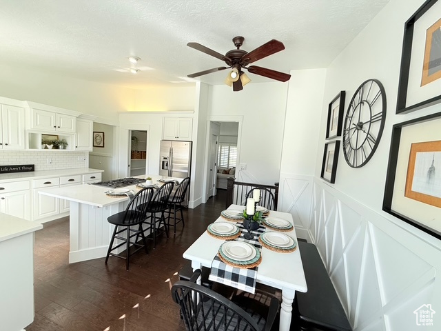 Dining area featuring a ceiling fan and dark wood-style floors