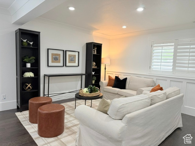 Living room with wood finished floors, recessed lighting, and crown molding