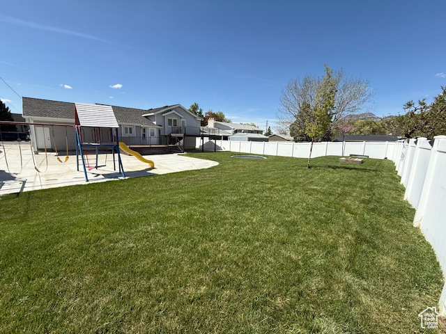 View of yard featuring a playground, a fenced backyard, and a patio area