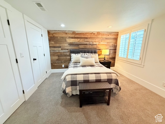 Bedroom with visible vents, wood walls, carpet floors, baseboards, and recessed lighting