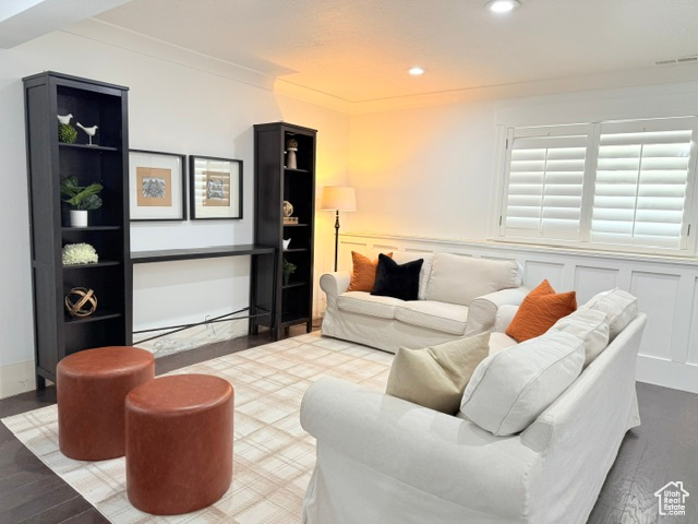 Living room featuring visible vents, ornamental molding, wainscoting, wood finished floors, and recessed lighting