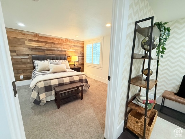Carpeted bedroom featuring baseboards, wood walls, recessed lighting, and wallpapered walls