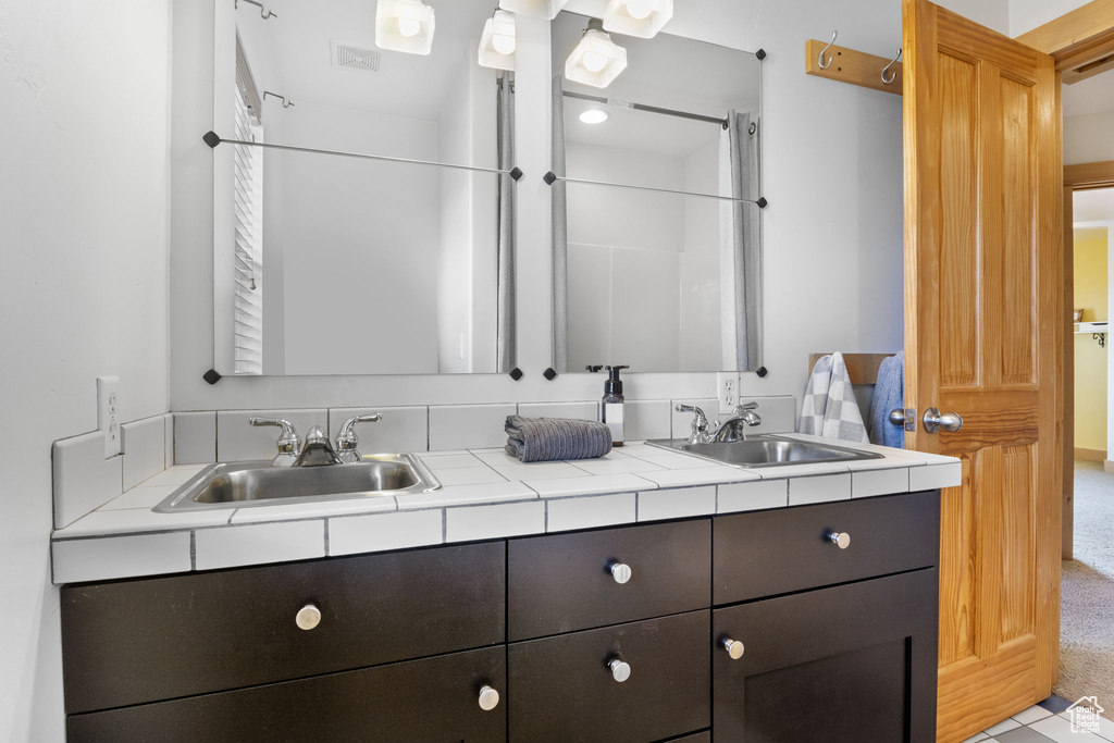 Bathroom featuring double vanity and a sink