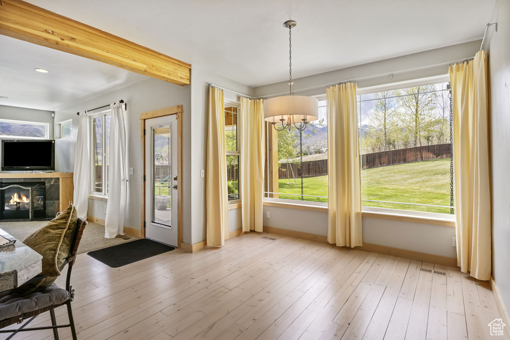 Entryway with a fireplace, wood-type flooring, a chandelier, baseboards, and visible vents