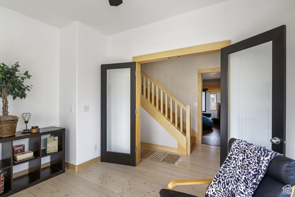 Living area with stairs, baseboards, and wood finished floors
