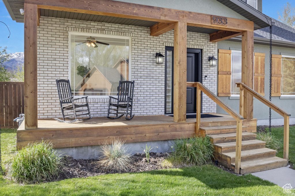 Doorway to property featuring brick siding, a mountain view, and fence