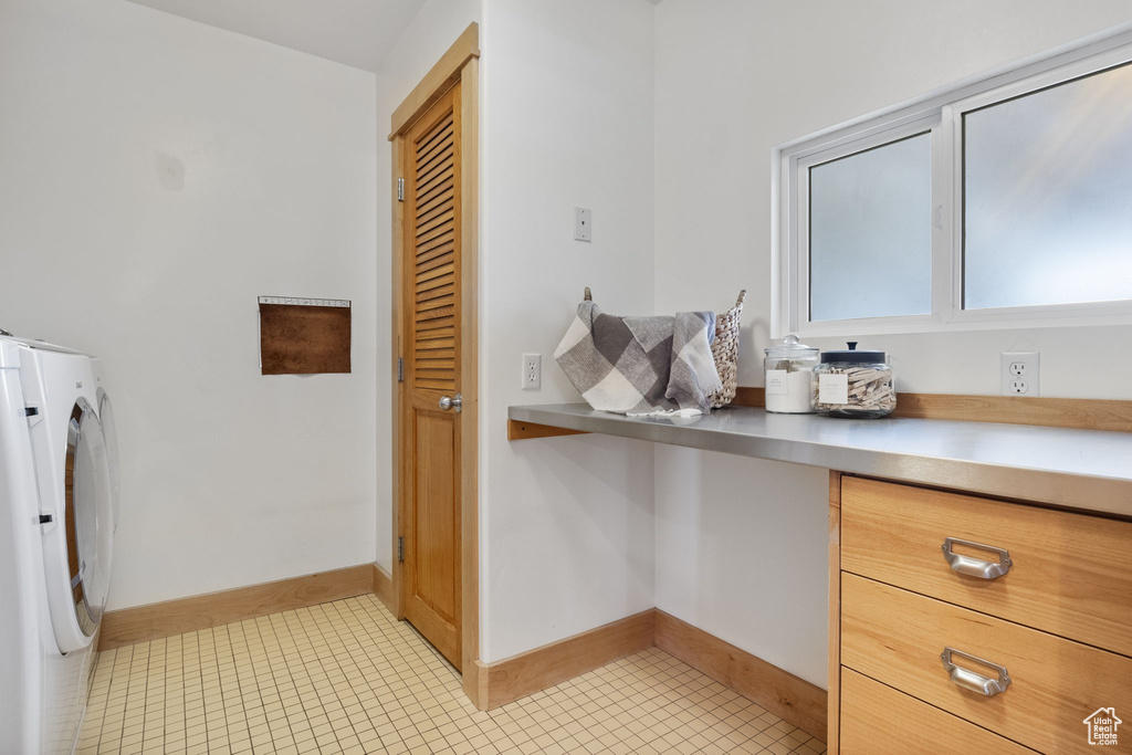 Bathroom with washer and dryer, baseboards, and tile patterned floors