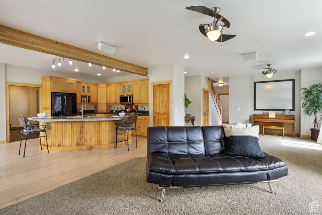 Living room with stairway, ceiling fan, beamed ceiling, and recessed lighting