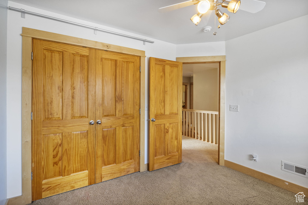 Unfurnished bedroom with carpet flooring, a ceiling fan, baseboards, and visible vents