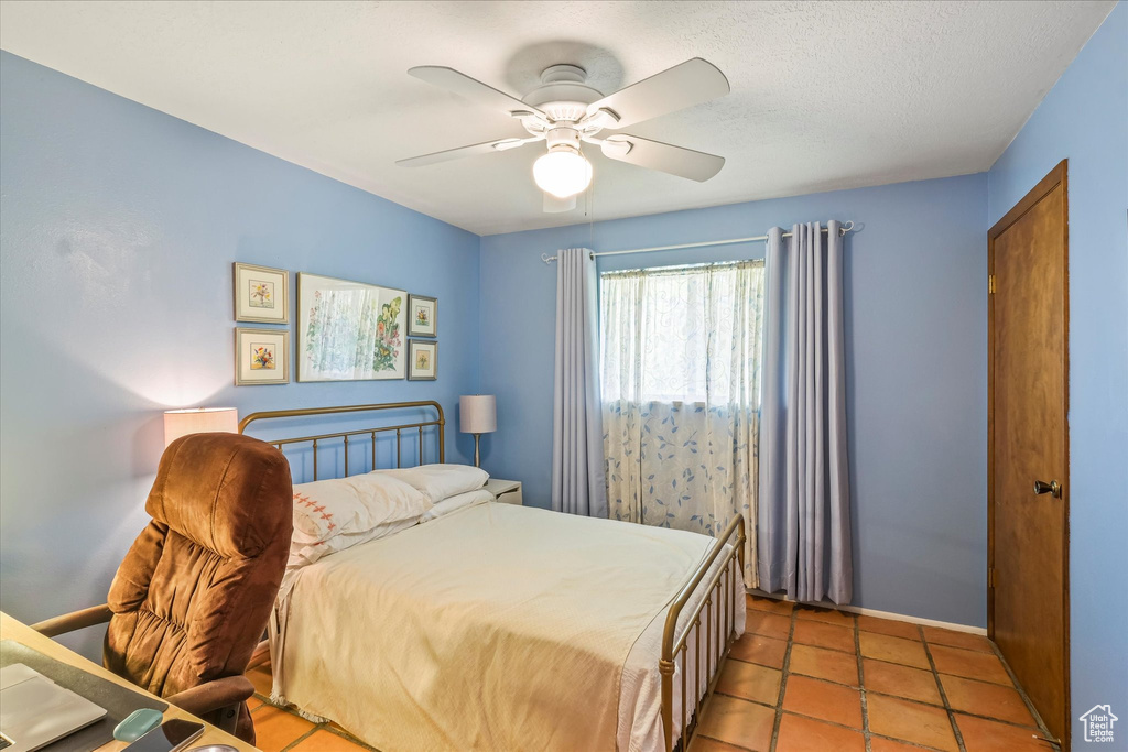 Bedroom featuring baseboards, ceiling fan, and light tile patterned flooring