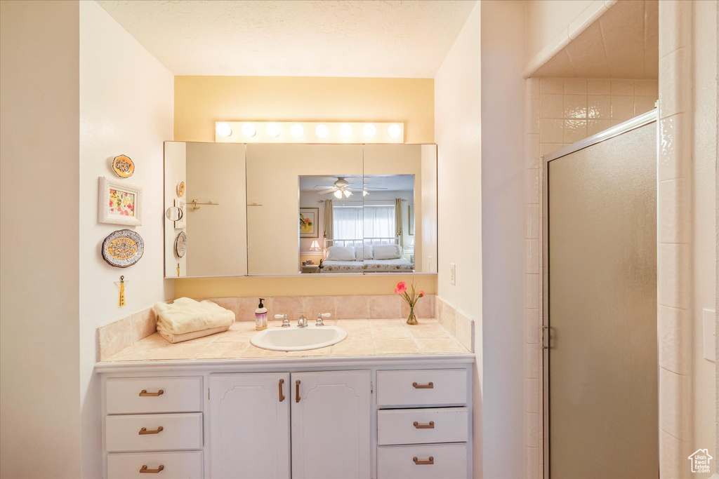Ensuite bathroom with vanity, ceiling fan, ensuite bathroom, and a stall shower
