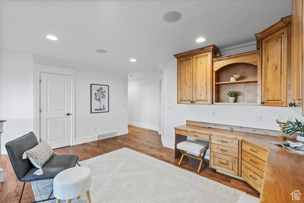 Office space with dark wood-style flooring, visible vents, baseboards, ornamental molding, and recessed lighting