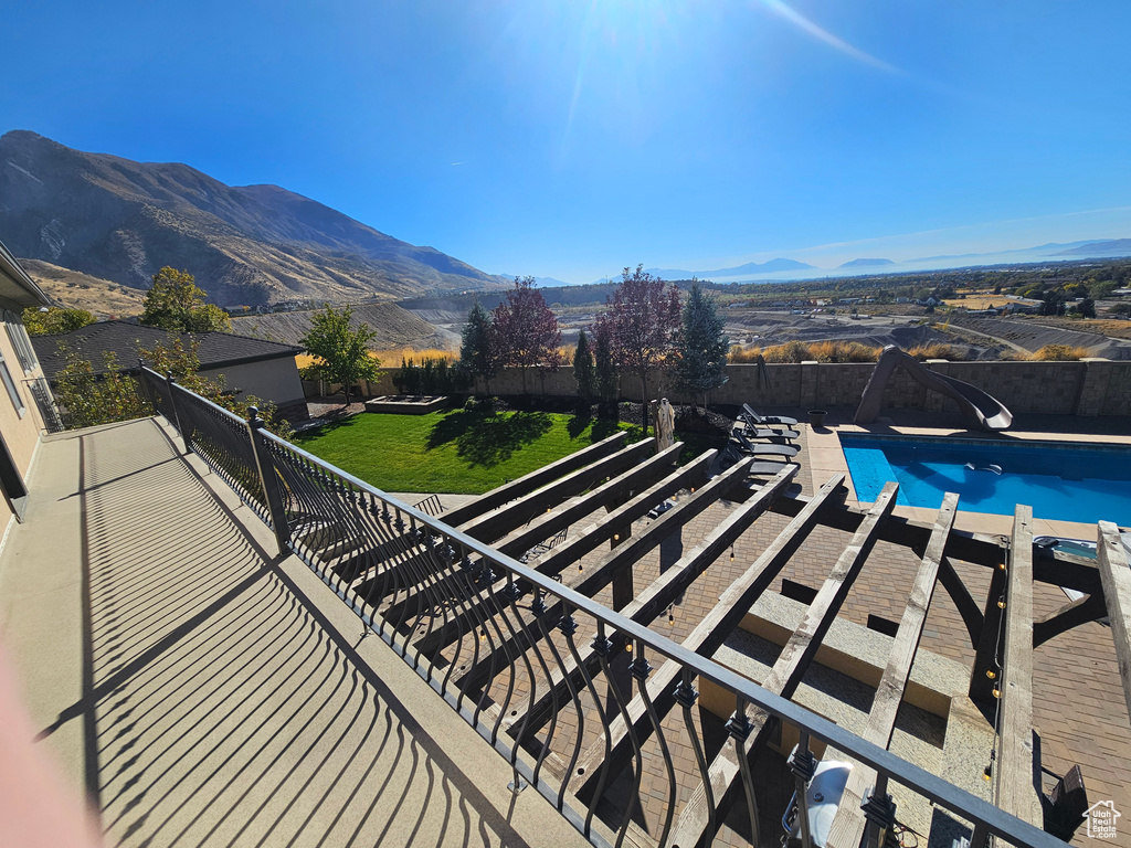 View of swimming pool with a fenced in pool, a mountain view, a fenced backyard, a yard, and a water slide