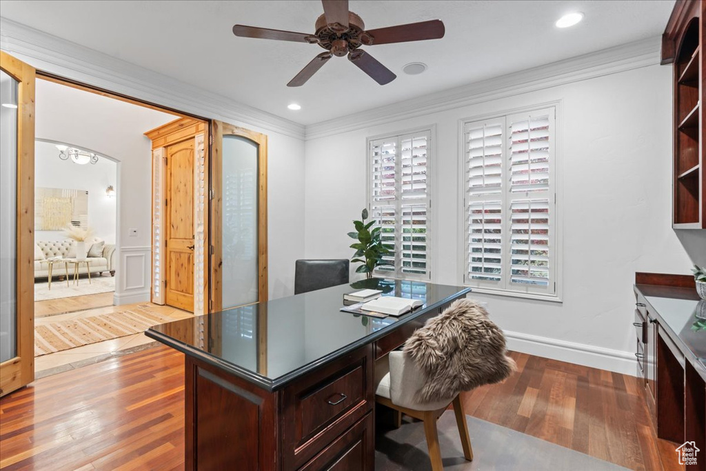 Office space with a ceiling fan, crown molding, arched walkways, recessed lighting, and light wood-style flooring