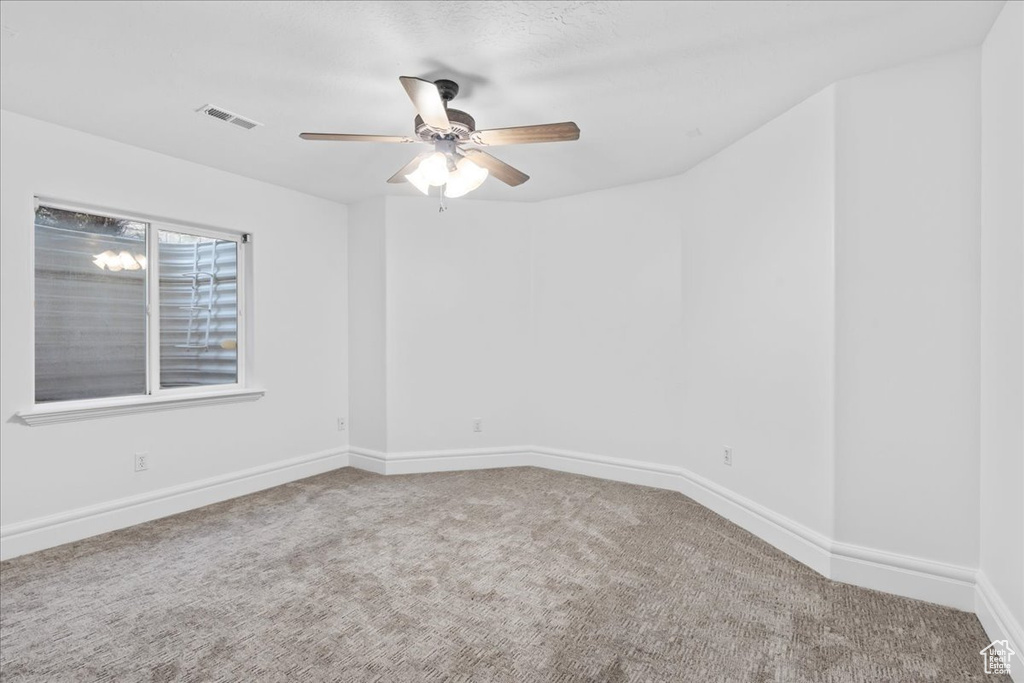 Unfurnished room with carpet floors, ceiling fan, visible vents, and baseboards