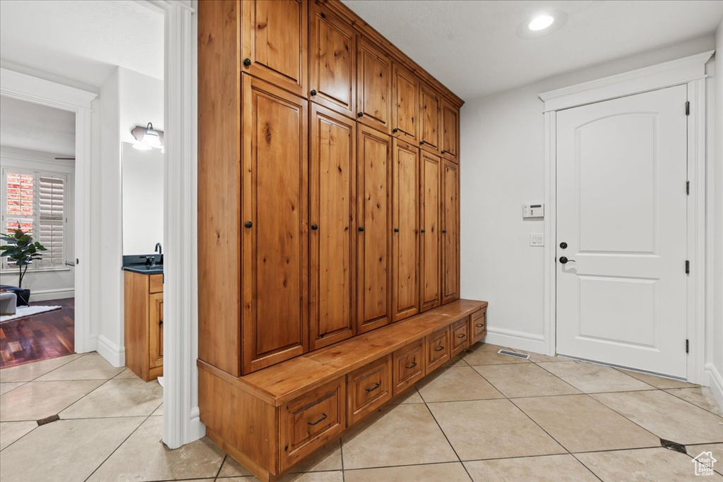 Mudroom with light tile patterned floors, baseboards, and recessed lighting