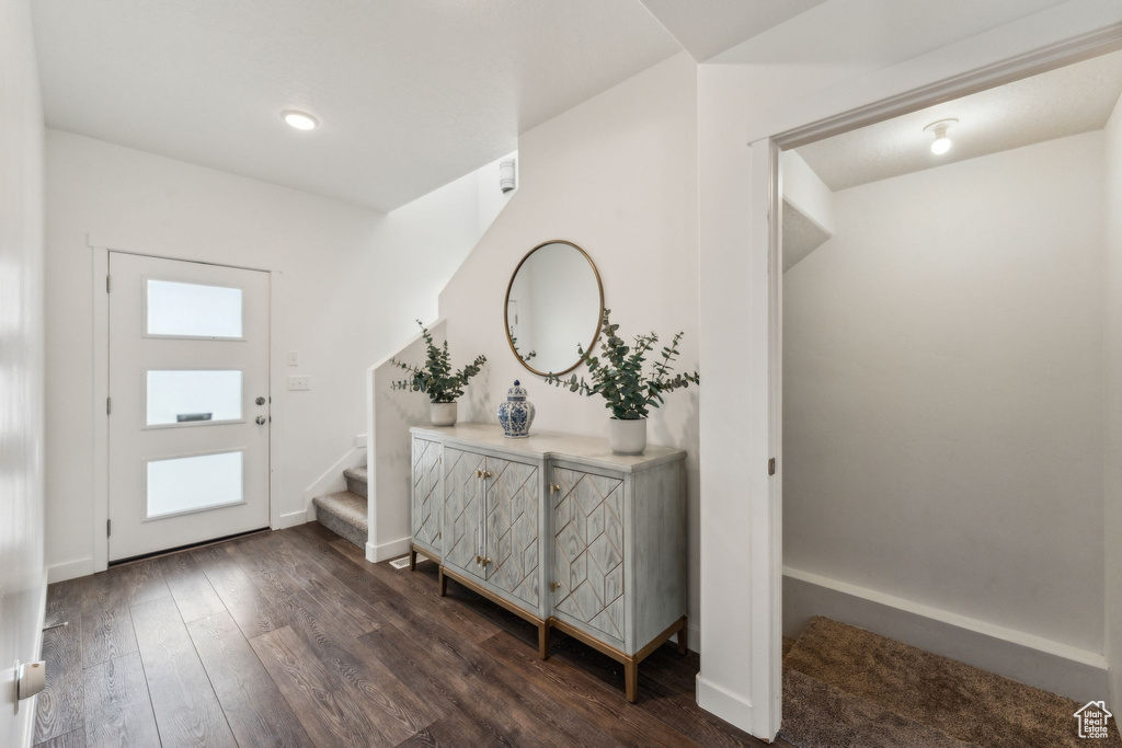Entryway featuring baseboards, stairs, and dark wood-type flooring