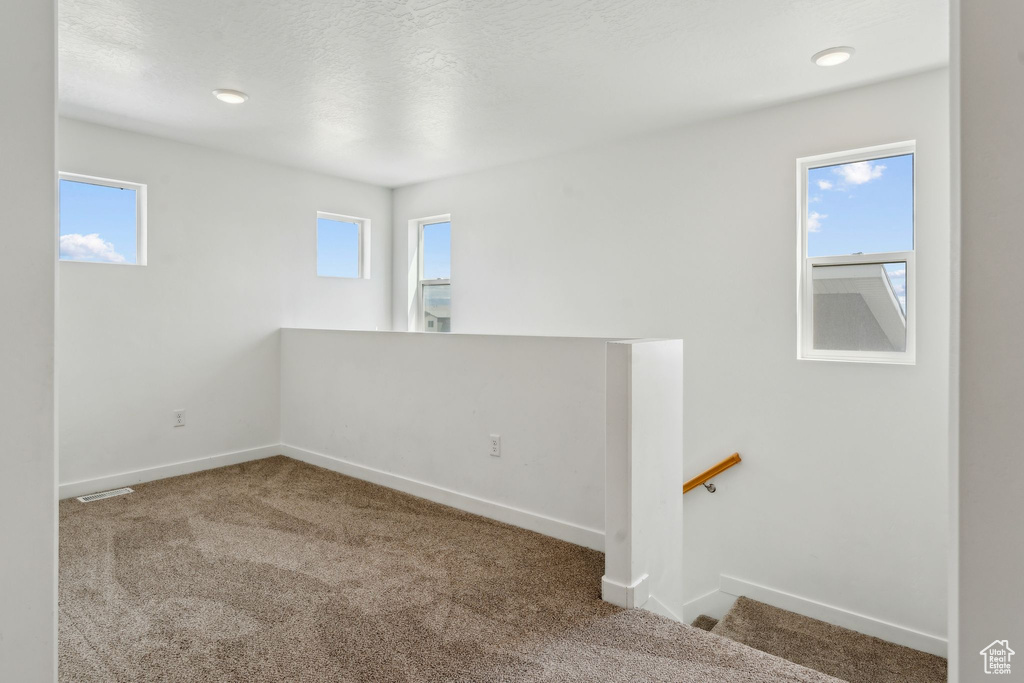 Carpeted spare room with baseboards and visible vents