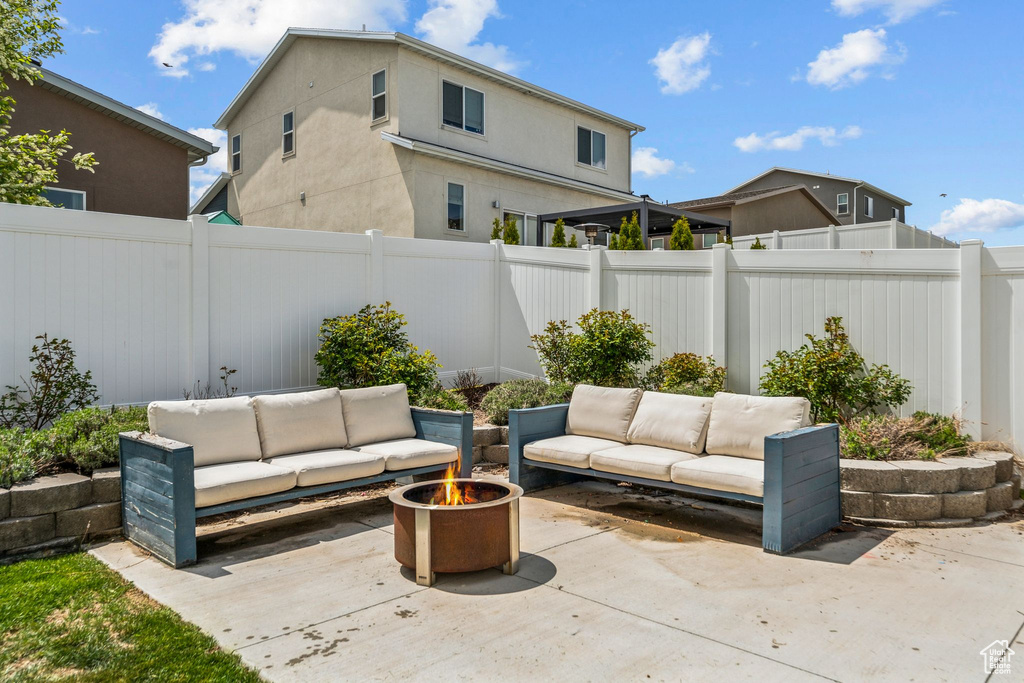 View of patio with a fenced backyard and an outdoor living space with a fire pit