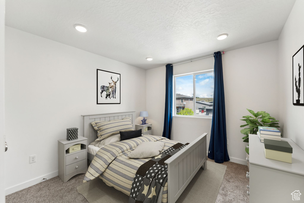 Bedroom with recessed lighting, a textured ceiling, light colored carpet, and baseboards