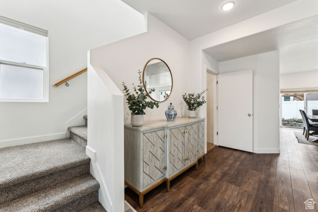 Interior space with baseboards, stairs, and dark wood-style floors