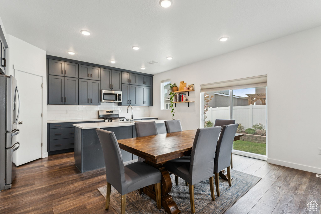 Dining space featuring a healthy amount of sunlight, baseboards, recessed lighting, and dark wood-type flooring