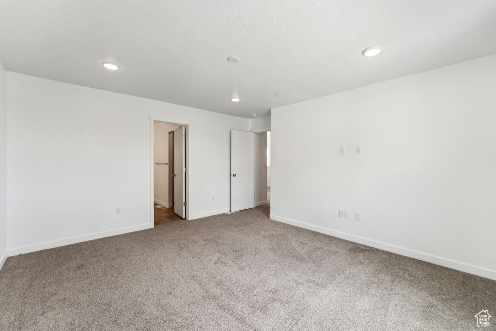 Carpeted spare room featuring baseboards and recessed lighting