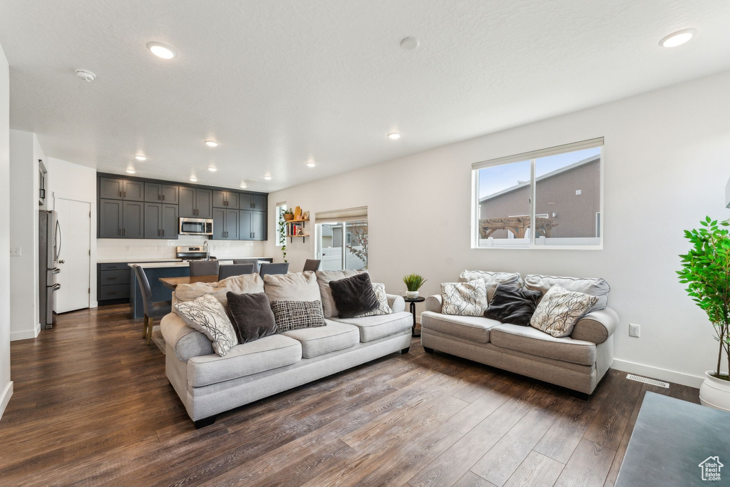 Living area featuring recessed lighting, baseboards, and dark wood finished floors
