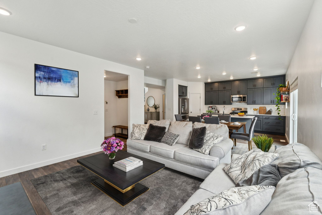 Living room with recessed lighting, baseboards, and dark wood-style floors