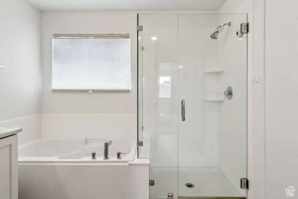 Full bath with a shower stall, a bath, and vanity