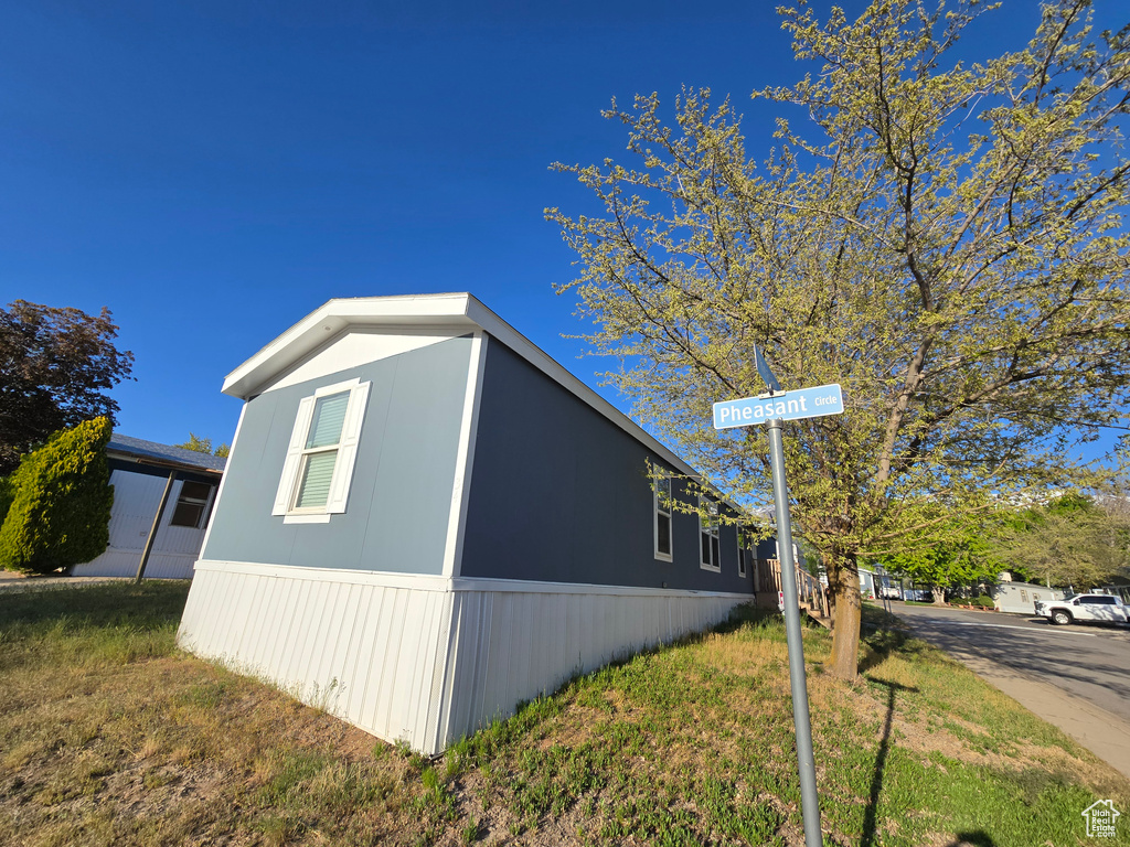 View of side of home featuring a yard