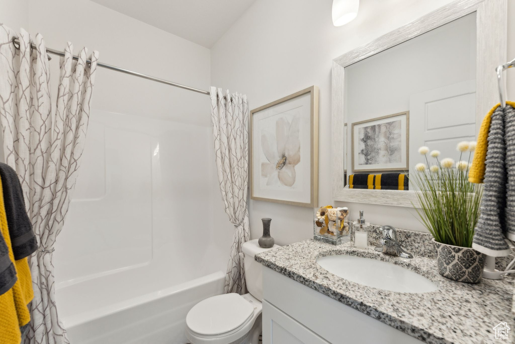 Full bathroom featuring vanity, shower / bath combo with shower curtain, and toilet