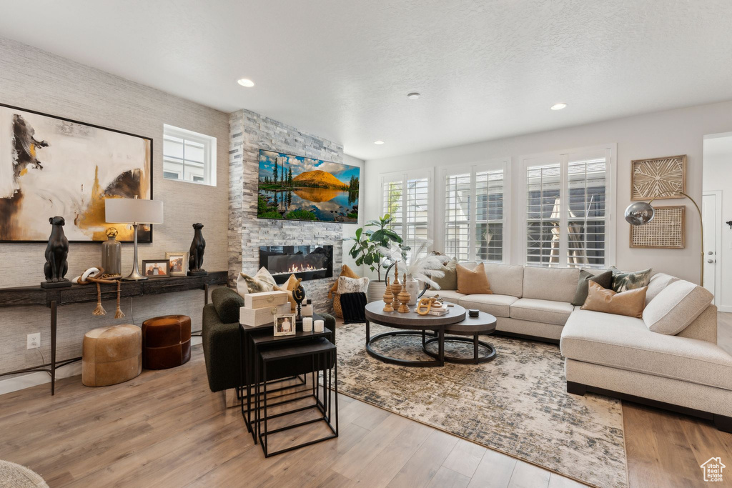 Living room with plenty of natural light, recessed lighting, wood finished floors, and a fireplace
