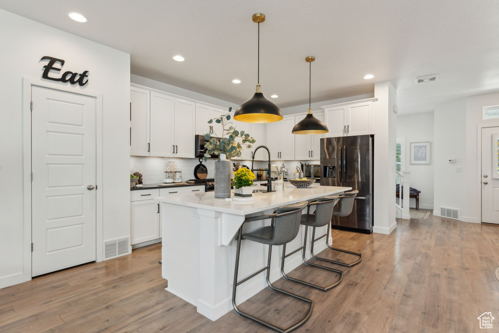 Kitchen featuring recessed lighting, visible vents, and fridge with ice dispenser