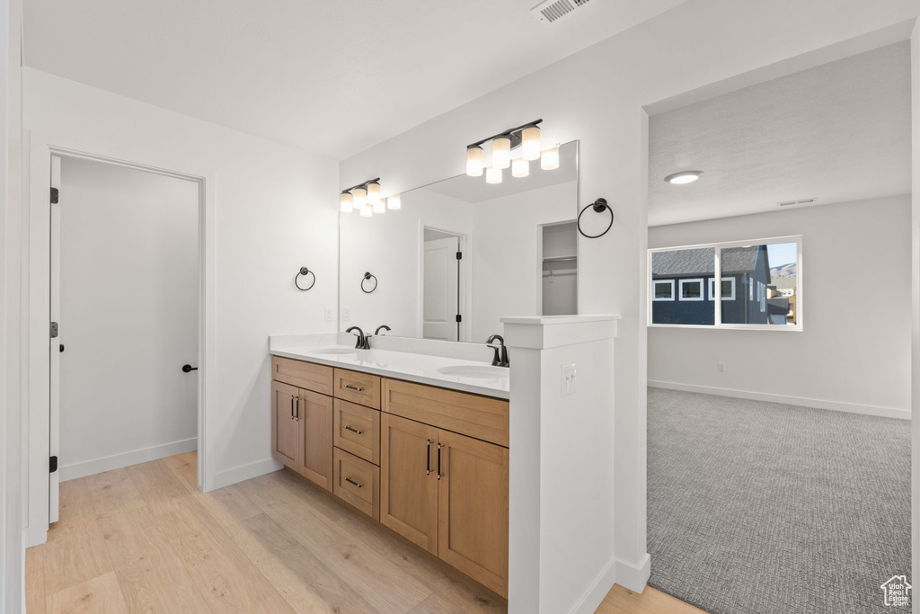 Full bathroom with a sink, baseboards, double vanity, and visible vents