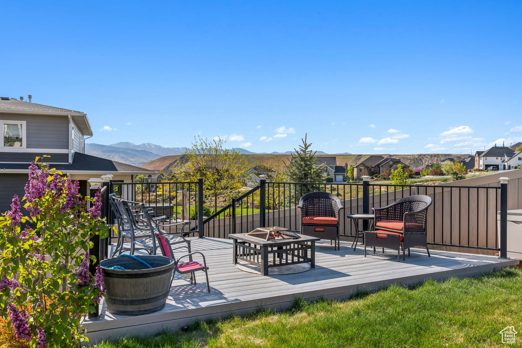 Deck with a residential view, a mountain view, and an outdoor fire pit