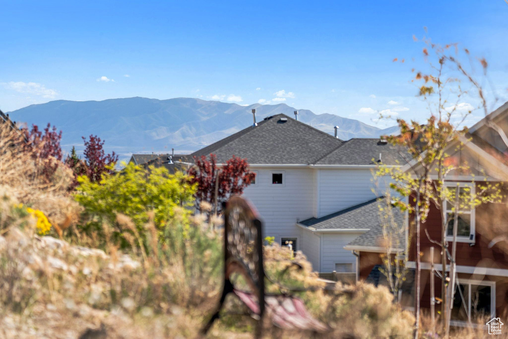 Rear view of property featuring a mountain view and roof with shingles