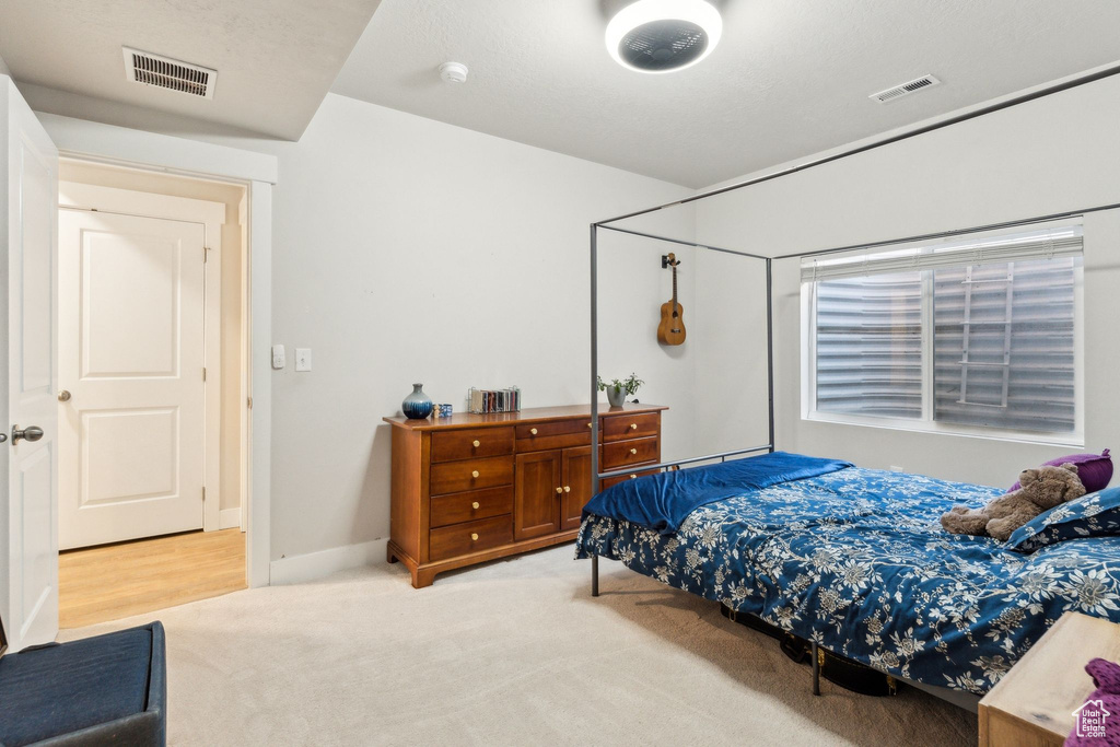 Bedroom with light colored carpet and visible vents