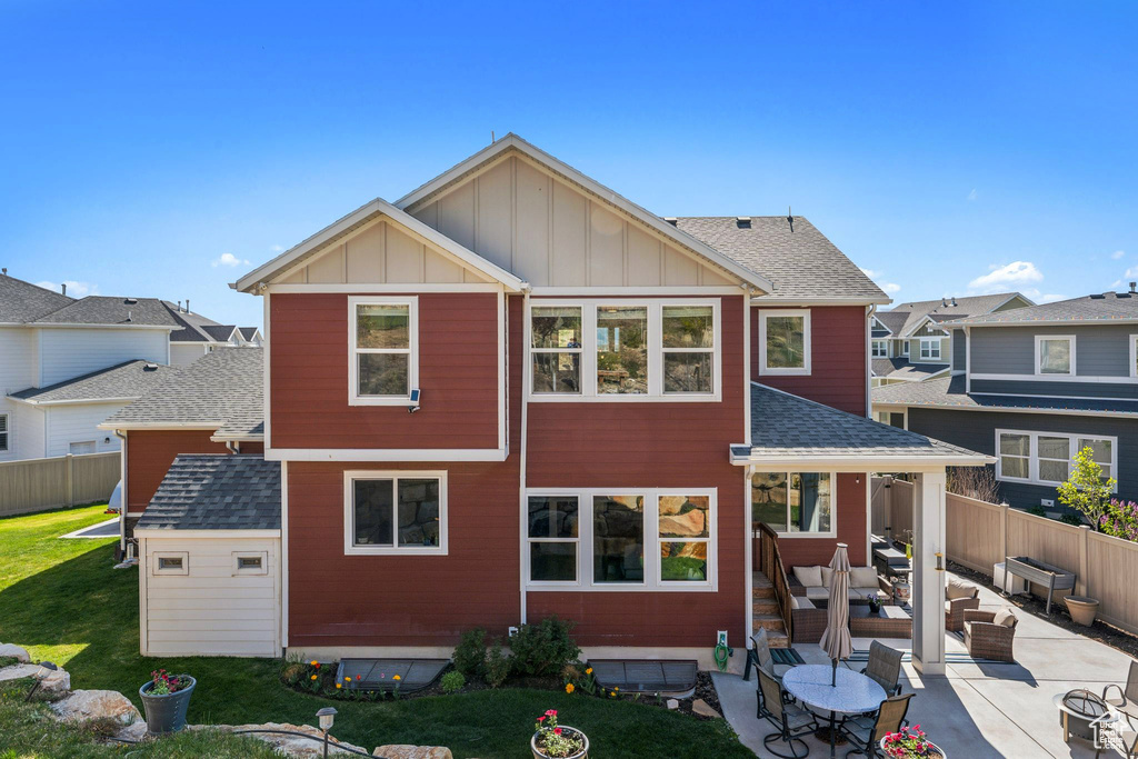 Back of house featuring board and batten siding, fence, outdoor lounge area, and a patio area
