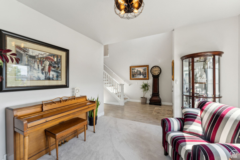 Living area featuring carpet floors, stairs, plenty of natural light, and baseboards