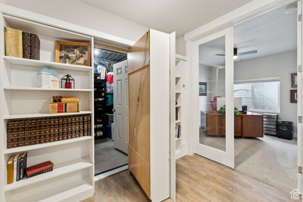 Interior space with a ceiling fan and light wood finished floors