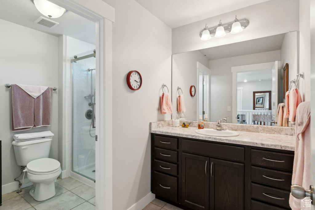 Bathroom featuring visible vents, tile patterned flooring, toilet, baseboards, and a stall shower