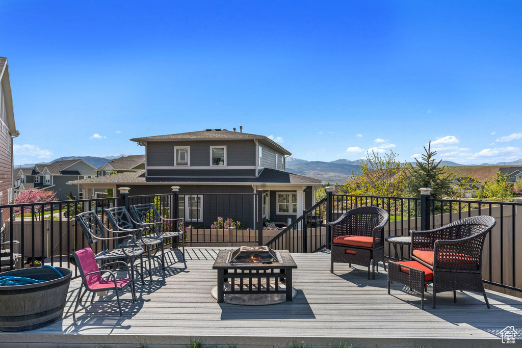 Wooden deck with a fire pit and a mountain view