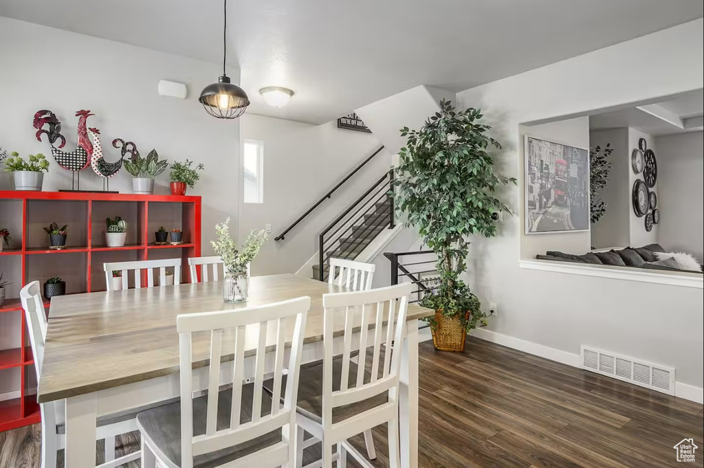 Dining area featuring stairway, baseboards, wood finished floors, and visible vents