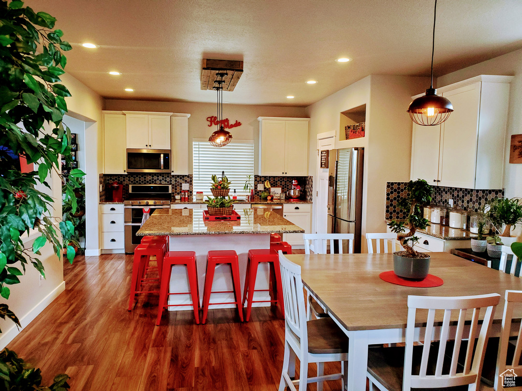 Kitchen with tasteful backsplash, a kitchen island, and stainless steel appliances