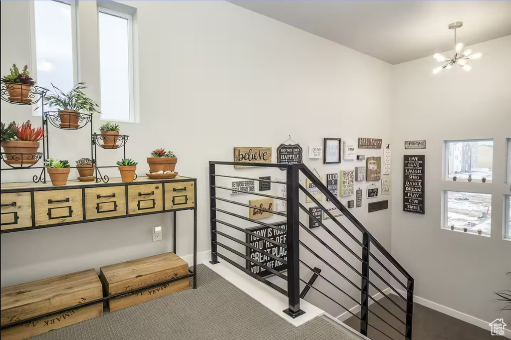 Staircase featuring baseboards and a notable chandelier