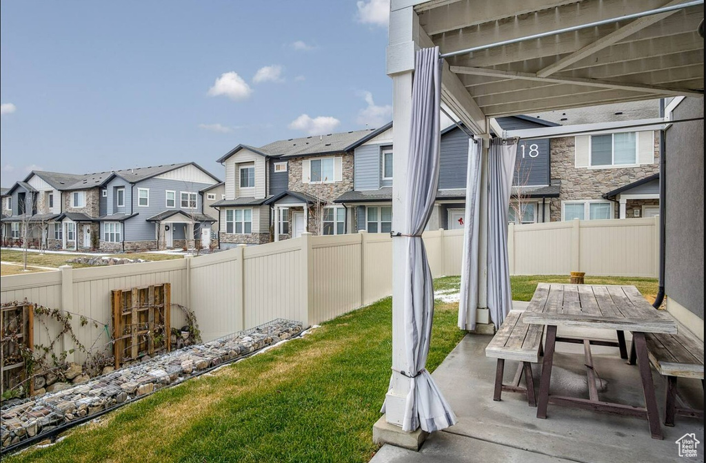 View of yard with a residential view, outdoor dining area, a fenced backyard, and a patio area