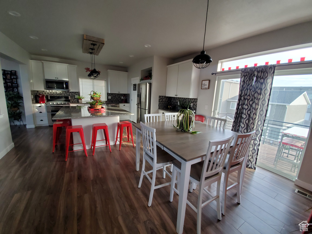 Dining space with dark wood-style flooring, visible vents, and recessed lighting